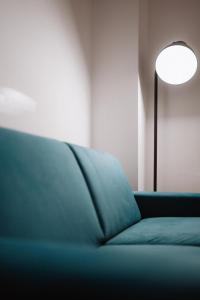 un divano blu in una stanza con una lampada di Brezza a Lesina