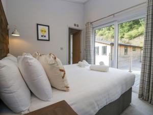 - une chambre avec un grand lit et une grande fenêtre dans l'établissement The Bothy, à Keswick