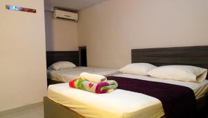 two beds in a hotel room with towels on them at HOTEL DASANTO HD in Barranquilla