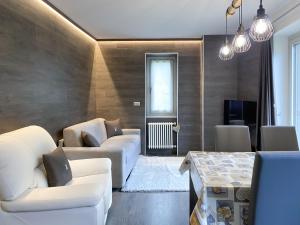 ein Wohnzimmer mit weißen Sofas und einem Tisch in der Unterkunft Angel's Home 2 in Ponte di Legno
