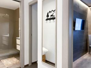 eine Glasschiebetür mit Fernseher im Badezimmer in der Unterkunft Angel's Home 2 in Ponte di Legno + 12 Fotos