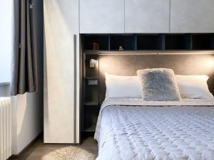 sypialnia z dużym łóżkiem z białymi poduszkami w obiekcie Angel's Home 2 w mieście Ponte di Legno
