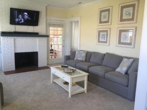 a living room with a couch and a fireplace at Shoreline Cottage - Oceanfront - North End VB in Virginia Beach