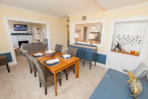 a living room with a wooden table and chairs at Shoreline Cottage - Oceanfront - North End VB in Virginia Beach +13 photos