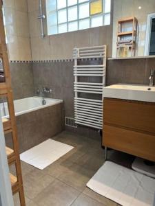 a bathroom with a sink and a tub and a sink and a bath tubermott at T3 Horizon- Face Gare -18 Min Paris in Villemomble