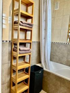 a bathroom with a wooden towel rack next to a bath tub at T3 Horizon- Face Gare -18 Min Paris in Villemomble