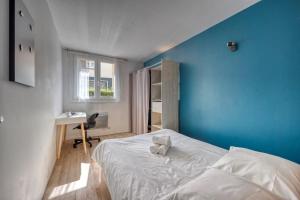 una camera da letto con parete blu, letto e scrivania di Blue Prosper - Centre-Ville a Grenoble