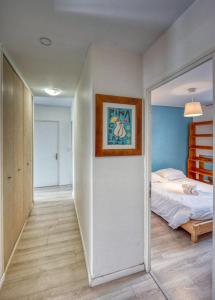 a bedroom with a bed and a painting on the wall at Blue Prosper - Centre-Ville in Grenoble
