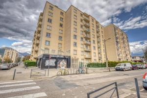 un grande edificio con auto parcheggiate in un parcheggio di Blue Prosper - Centre-Ville a Grenoble
