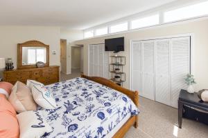 ein Schlafzimmer mit einem Bett mit einer blauen und weißen Decke in der Unterkunft Shoot The Breeze - North End VB in Virginia Beach