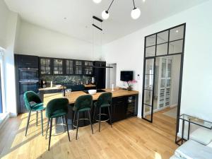a kitchen with a wooden table and green chairs at Barrierefr. Penthouse am Hafen mit Sonnen-Terrasse in Eckernförde