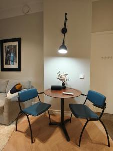 sala de estar con mesa, sillas y sofá en Design studio in Kamppi en Helsinki