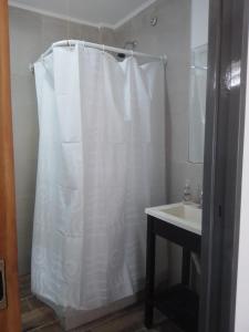 baño con cortina de ducha blanca y lavamanos en Casa Namasté en Mar del Plata