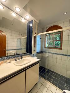 ein Bad mit einem Waschbecken und einem Spiegel in der Unterkunft Suítes Casa Aurora in Canela