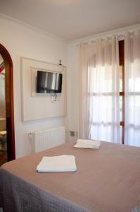 a bedroom with a bed with two towels on it at Suítes Casa Aurora in Canela