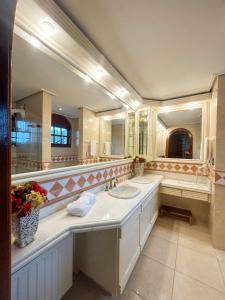 ein Badezimmer mit zwei Waschbecken und zwei Spiegeln in der Unterkunft Suítes Casa Aurora in Canela