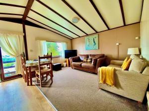 a living room with a couch and a table at The Raddle Inn Log Cabins in Croxden