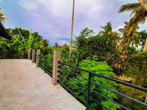 a balcony with a black fence and some trees at The Beau Beach Weligama in Weligama
