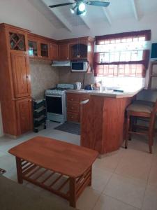a kitchen with wooden cabinets and a table in it at Joyville in Bridgetown
