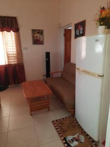 ein Wohnzimmer mit einem Kühlschrank und einem Sofa in der Unterkunft Joyville in Bridgetown
