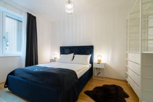 een slaapkamer met een bed met een blauw hoofdeinde en een raam bij Vienna Residence, Vorgartenstraße - Leopoldstadt in Wenen