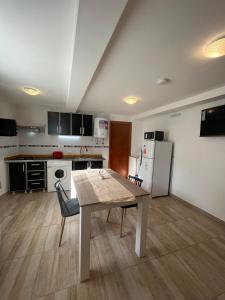 烏斯懷亞的住宿－Ushuaia_aparts Depto 1，一间带桌子的厨房和一间带冰箱的厨房