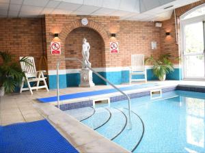 a swimming pool with a statue in a building at Stone House Hotel ‘A Bespoke Hotel’ in Stone