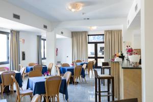 une salle à manger avec des tables et des chaises bleues dans l'établissement Grand Hotel Selinunte, à Marinella di Selinunte