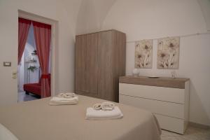 a bedroom with two towels on a bed and a dresser at Casa Pasadame' in Ostuni
