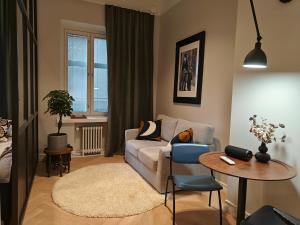 uma sala de estar com um sofá e uma mesa em Design studio in Kamppi em Helsínquia