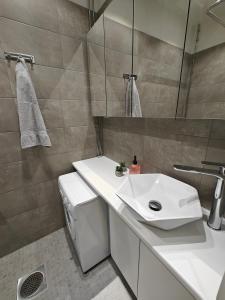 a bathroom with a white sink and a mirror at Design studio in Kamppi in Helsinki