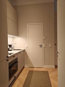 a kitchen with a door leading into a kitchen with a counter at Design studio in Kamppi in Helsinki