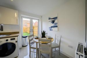 uma cozinha e sala de jantar com mesa e cadeiras em 30 percent monthly deal on 3 BR house, Sleeps 6 with Full kitchen, garden and free parking - FREE WI-fi near Milton Keynes Bowl em Bedford