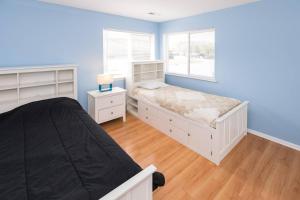a bedroom with blue walls and a bed and a window at The Beacon at Playa Rana in Virginia Beach