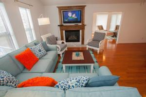 維吉尼亞海灘的住宿－Turtle Cove - North End VB，客厅设有蓝色的沙发和壁炉