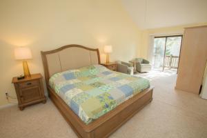 維吉尼亞海灘的住宿－Turtle Cove - North End VB，一间卧室配有一张床和一张带两盏灯的桌子。