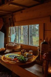 una mesa de madera con un plato de comida. en Ainutlaatuinen metsämajoitus en Enontekiö