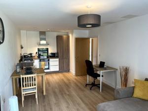 a living room with a couch and a table and a kitchen at Modern 1 Bedroom Serviced Apartment - Near City Centre in Doncaster