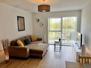 a living room with a couch and a large window at Modern 1 Bedroom Serviced Apartment - Near City Centre in Doncaster
