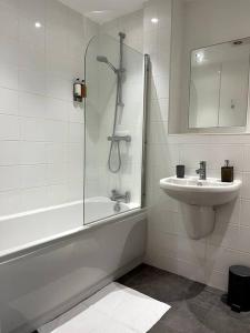 a bathroom with a shower and a sink and a tub at Modern 1 Bedroom Serviced Apartment - Near City Centre in Doncaster