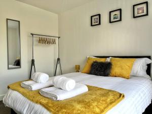 una camera da letto con un grande letto con asciugamani di Modern 1 Bedroom Serviced Apartment - Near City Centre a Doncaster