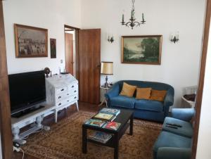 salon z niebieską kanapą i telewizorem w obiekcie Casa de alojamento local (T2) Queluz de Baixo w mieście Oeiras