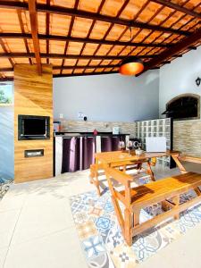 sala de estar con mesa de madera y cocina en RiqueHouse: Piscina, churrasqueira a 500m da praia, en Itaipuaçu