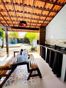 un patio con una mesa de madera y una barra en RiqueHouse: Piscina, churrasqueira a 500m da praia, en Itaipuaçu