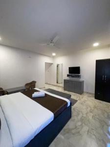 a bedroom with a bed and a flat screen tv at Harmony Palace in Mahabaleshwar