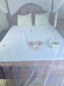a bedroom with a bed with two towels on it at CLASSIC VISITORS HOUSE in Nasulo