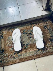 a pair of white shoes sitting on a rug at CLASSIC VISITORS HOUSE in Nasulo