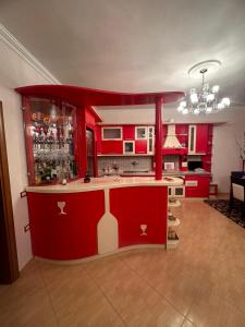 a kitchen with red cabinets and a bar in it at Villa Mile in Berat
