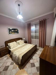 a bedroom with a bed and a table and a window at Villa Mile in Berat