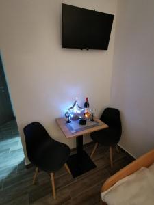 ein kleiner Tisch mit zwei Stühlen und ein TV an der Wand in der Unterkunft Golijski Biseri in Novi Pazar